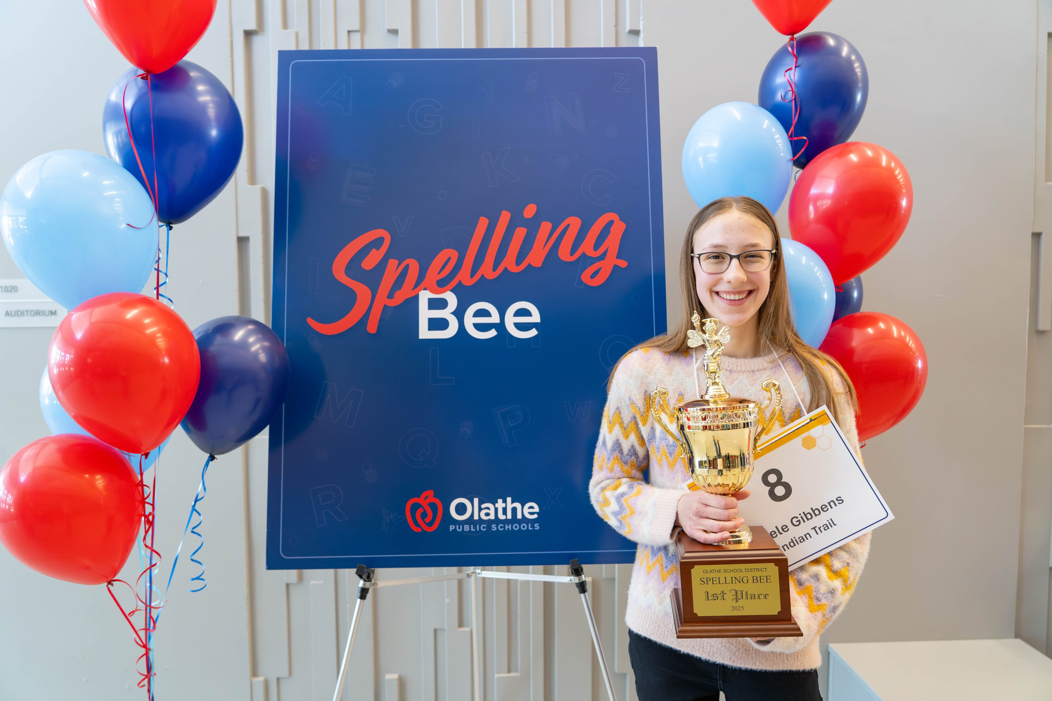 Adele Gibbens holds her spelling bee trophy
